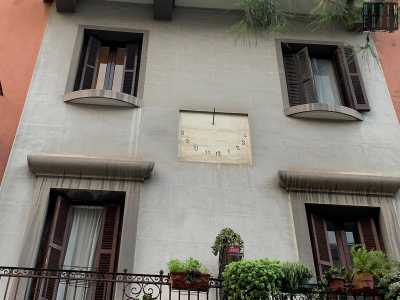 ...che, tra il primo e il secondo piano, mostra al centro una meridiana in cemento bianco